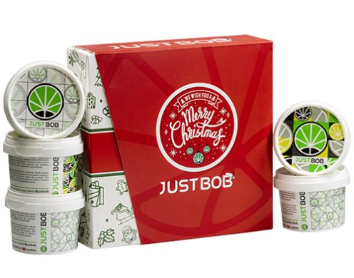 Offene Justbob XMAS KIT Box mit mehreren Behältern von legalem CBD-Blüten, mit Weihnachtsbranding und Cannabisblatt-Design, ideal für Feiertagsgeschenke